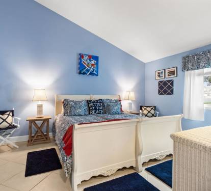 Drift off to sleep in your cozy coastal bedroom, where soothing blue walls and beachy decor create the perfect seaside escape.