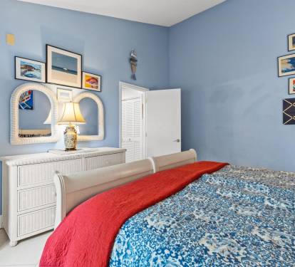 Drift off in your coastal-themed bedroom, where calming blue walls and ocean artwork create a seaside sanctuary for peaceful nights.