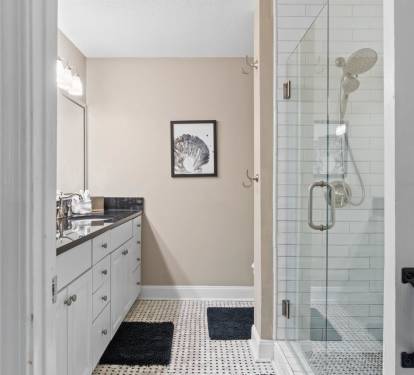 Step into your pristine bathroom with elegant subway tile shower, classic vanity, and charming coastal artwork creating a spa-like retreat.