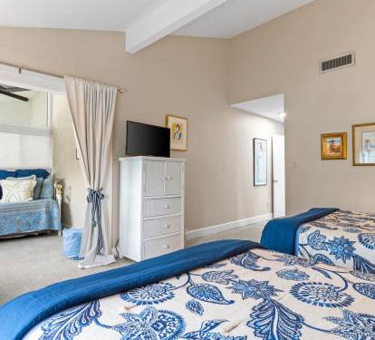 Unwind in your serene bedroom sanctuary with coastal blue accents, soft linens, and peaceful natural light filtering through elegant curtains.