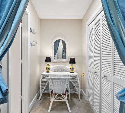 Step into your private dressing area where elegant blue curtains frame a charming white vanity perfect for your morning routine.