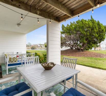 Your private covered patio offers charming garden views where you can enjoy morning coffee at the outdoor dining table.