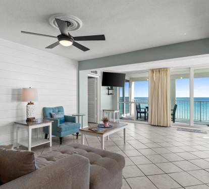 Relax in your bright oceanfront living room where coastal comfort meets stunning sea views through floor-to-ceiling windows.
