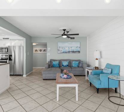 Relax in your coastal-inspired living room with comfortable seating and modern kitchen convenience.