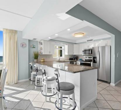 Whip up morning coffee at your oceanfront kitchen island while watching waves through floor-to-ceiling windows—your perfect beach getaway awaits.