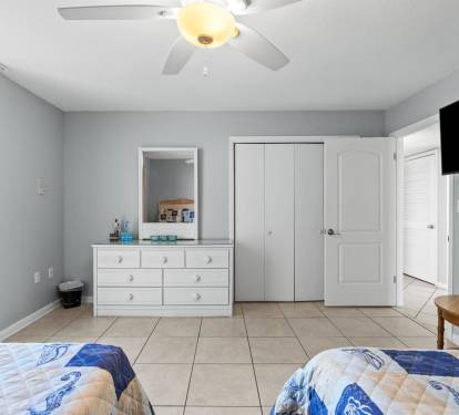 Wake up in your bright, airy bedroom with coastal charm. Enjoy pool views from your window and stay comfortable with the ceiling fan overhead.