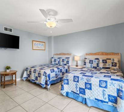 Unwind in your tranquil bedroom featuring twin beds with coastal-themed linens, perfect for sharing laughs before drifting off to sleep.