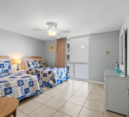 Relax in your bright bedroom with two comfortable beds, gentle ceiling fan breeze, and convenient mini-fridge for midnight snacks.