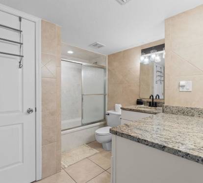 Luxurious bathroom with granite countertops and glass shower awaits your morning routine.