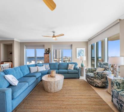 Unwind in your bright, coastal living room where ocean views and plush blue seating create the perfect atmosphere for relaxation.