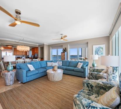 Relax in your bright coastal living space with ocean views from every window and comfortable blue sectional seating.