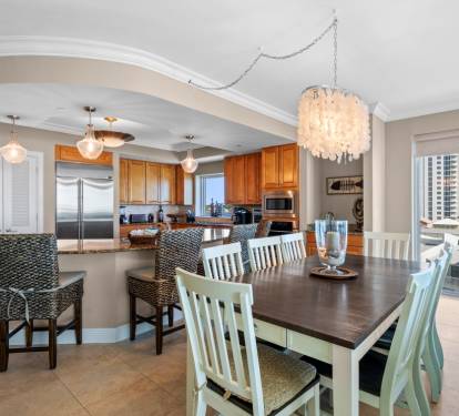 Your open-concept kitchen and dining space features elegant pendant lighting and stunning city views through floor-to-ceiling windows.