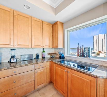 Your fully equipped kitchen features granite counters and city views, perfect for preparing meals while enjoying the urban skyline.