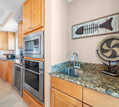 Prepare your favorite meals in this fully equipped kitchen with granite counters, stainless appliances, and ocean-inspired décor.
