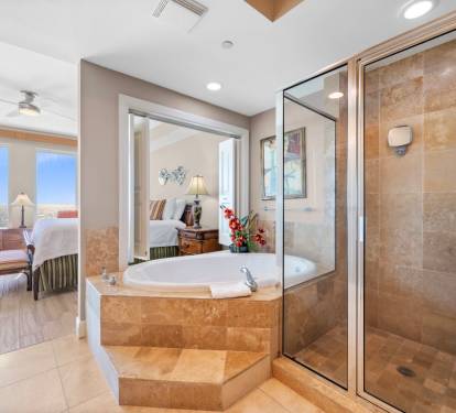 Indulge in your private spa retreat with a luxurious soaking tub and spacious glass-enclosed shower, all with stunning views.