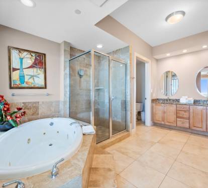 Unwind in your luxurious spa-style bathroom featuring a deep soaking tub and elegant glass-enclosed shower.