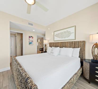 Unwind in your coastal-inspired bedroom with woven headboard, crisp linens, and warm lighting for ultimate relaxation.
