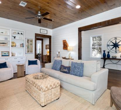 Sink into plush coastal comfort where rustic wood ceilings meet crisp white walls, creating your perfect beach retreat sanctuary.