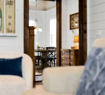 Sink into plush seating in your charming cottage-style retreat, where nautical touches and warm wood beams create the perfect coastal escape.