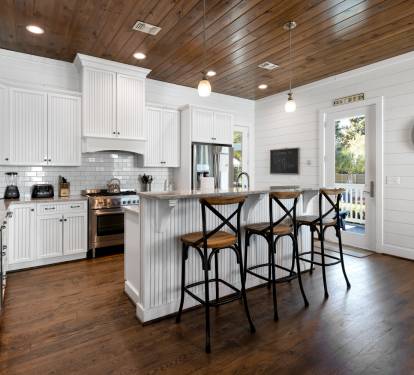 Your spacious farmhouse kitchen features stunning wood-plank ceilings, gleaming granite counters, and a breakfast bar perfect for morning coffee.