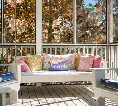 Unwind on your private screened porch with comfy seating and colorful pillows, surrounded by beautiful autumn foliage.