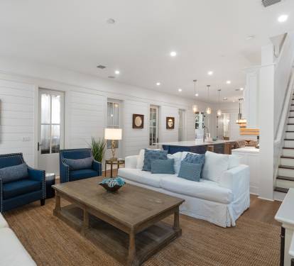 Unwind in your bright coastal living room with plush seating, whitewashed walls, and an open layout that flows seamlessly into the kitchen.