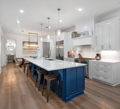 Your gourmet kitchen awaits with gleaming white countertops, a stunning navy island, and warm wood floors that invite barefoot mornings.
