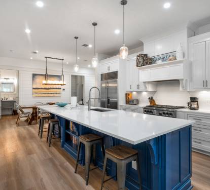 Your chef-worthy kitchen features a stunning blue island, gleaming quartz counters, and top-tier appliances ready for memorable meals together.