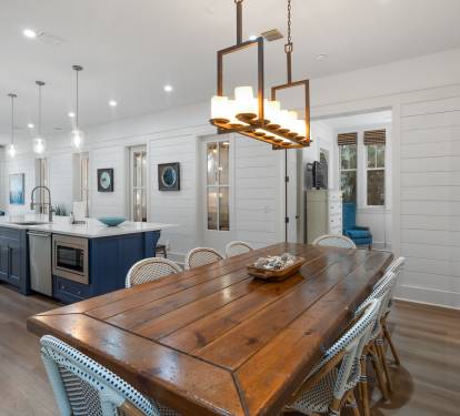 Gather around this stunning farmhouse dining space where warm wood meets coastal charm, perfect for memorable meals.