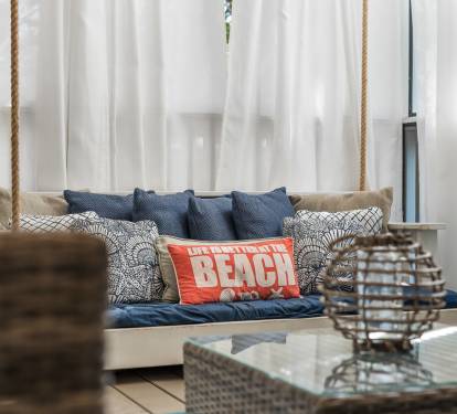 Unwind on your private swing daybed, draped in flowing curtains with coastal-inspired pillows creating the perfect beachside retreat.