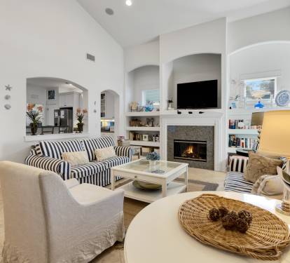 Unwind in your elegant living room with soaring arched ceilings, cozy fireplace, and thoughtfully arranged seating perfect for memorable gatherings.