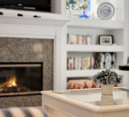 Curl up in this cozy living room where crackling flames and built-in bookshelves create your perfect reading retreat.
