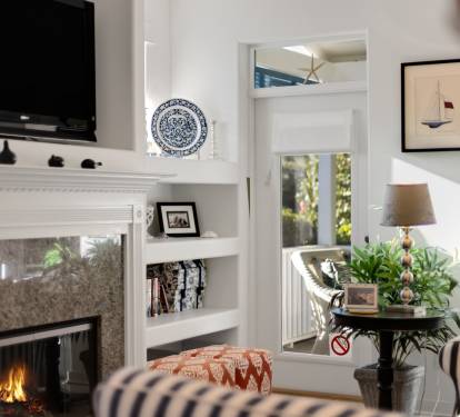 Cozy up by your crackling fireplace while enjoying modern amenities like the flat-screen TV in this elegantly appointed living space.
