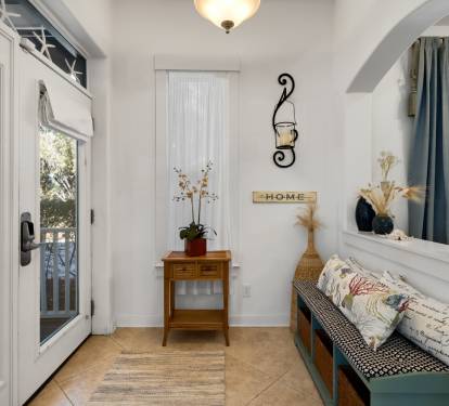 Your charming entryway welcomes you with warm lighting, cozy seating, and thoughtful touches that make arrival feel like coming home.