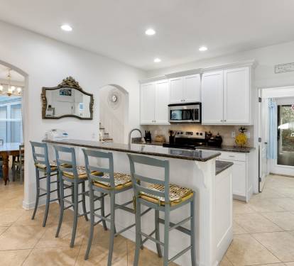 You'll love gathering around this spacious kitchen island while preparing meals together, with its elegant granite countertops and charming breakfast bar seating.