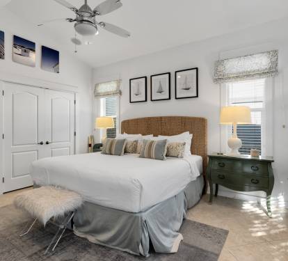 Unwind in your serene bedroom sanctuary featuring a plush king bed, woven headboard, and elegant nautical touches that whisper coastal tranquility.