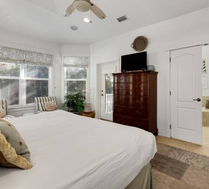 Drift off to sleep in your serene master bedroom, complete with cozy linens and warm natural light streaming through patterned window shades.