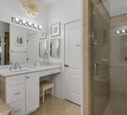 Refresh in your elegant bathroom featuring dual vanities, sparkling mirrors, and a luxurious walk-in shower with beautiful tiling.