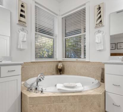 Luxurious master bath with soaking tub where you can unwind after your day, bathed in natural light from windows.