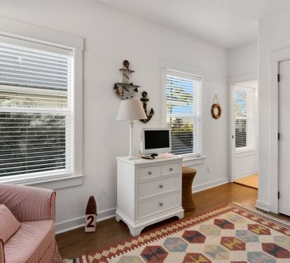 Curl up in your cozy nautical-themed bedroom, where warm stripes and charming coastal touches create the perfect retreat.