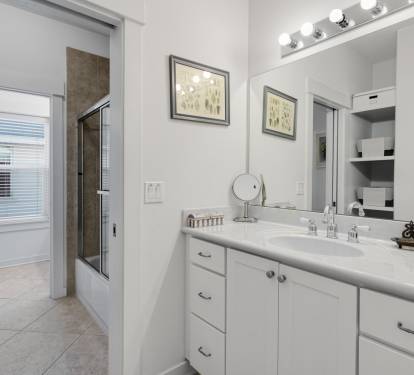 Step into your pristine bathroom with gleaming countertops, elegant vanity lighting, and a spacious shower waiting for your morning routine.