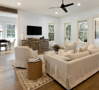 Relax in your elegant living space with shiplap walls, plush seating, and modern amenities for the perfect getaway.