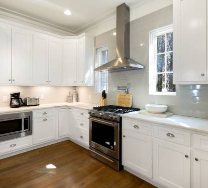 Your spacious chef's kitchen gleams with pristine white cabinets, modern stainless appliances, and everything you need to create memorable meals during your stay.