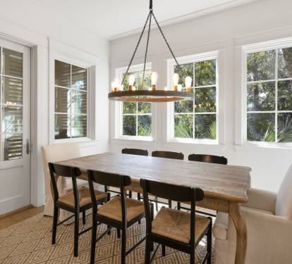 Gather around this beautiful dining table where natural light pours through large windows, creating the perfect ambiance for memorable meals together.