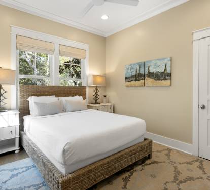 Slip into crisp white linens in your serene retreat, where warm natural light and coastal artwork create the perfect atmosphere for rest.