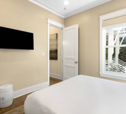 Relax in your serene bedroom with plush bedding, elegant decor, and a wall-mounted TV for cozy evenings.