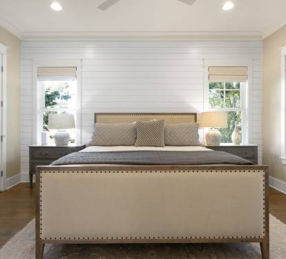 Sink into this elegant bedroom's plush bedding after your day exploring, with natural light streaming through stylish windows.