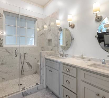 Step into your luxurious marble bathroom with a spacious walk-in shower and elegant dual vanities, perfect for your morning routine.