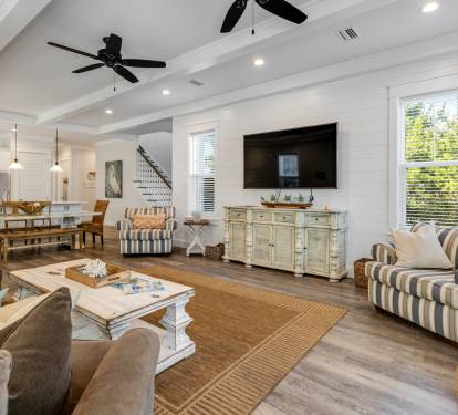 Relax in your spacious coastal living room with soaring ceilings, cozy seating, and natural light streaming through large windows.