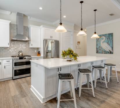 Your gourmet kitchen awaits with gleaming counters, modern appliances, and stylish island seating for memorable meal prep and casual dining together.